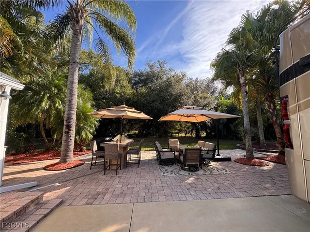 a patio with a table and chairs under an umbrella