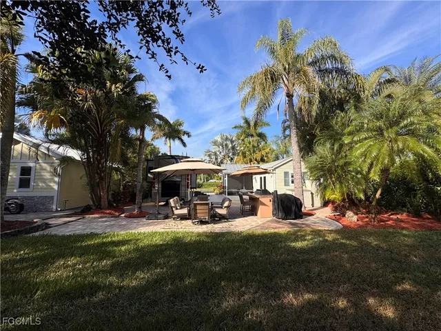 a view of a patio with table and chairs under an umbrella