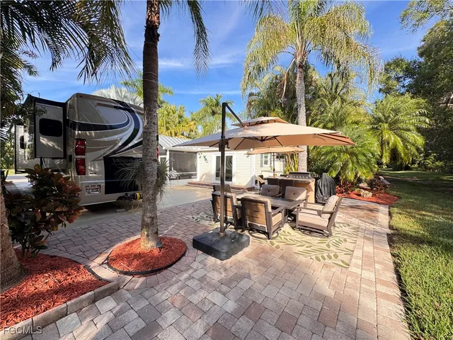 a view of a patio with a table and chairs under an umbrella