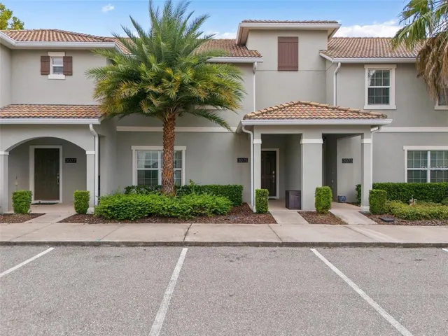 a front view of a house with garage and plants