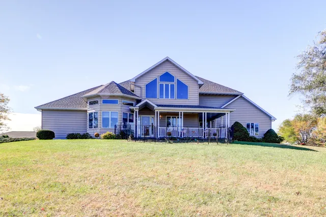 a view of a house with a big yard and large trees