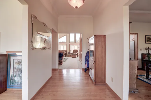 a view of a hallway with wooden floor and windows