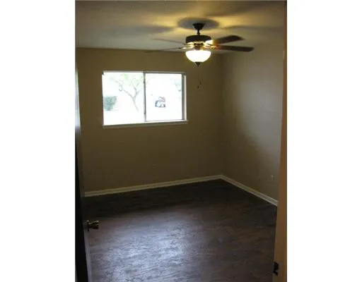 a view of a small space with wooden floor and a window