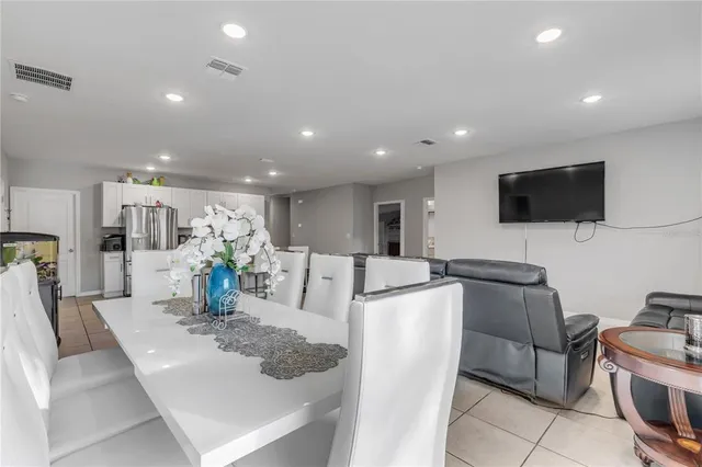 a living room with furniture a flat screen tv and kitchen view