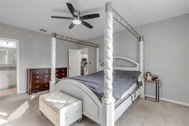 a bed room with a bed and a ceiling fan