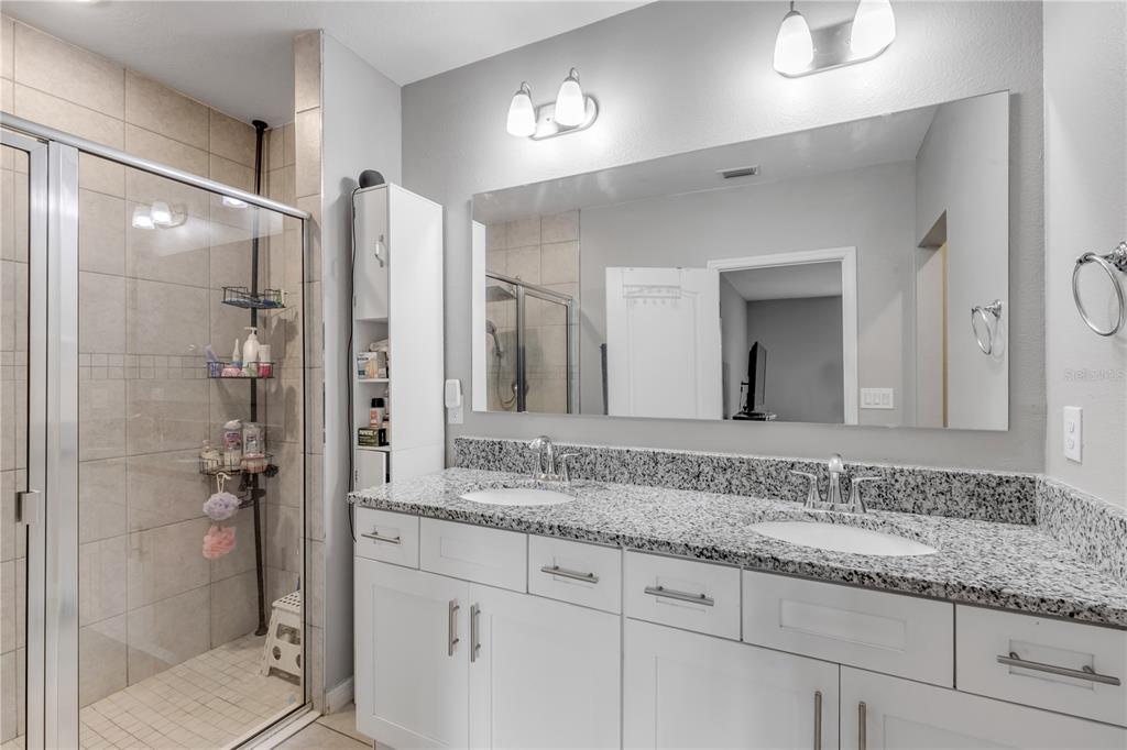 1017 36th Street Edgewater, FL 32141 - Photo 14 of 29 a bathroom with a granite countertop sink mirror and shower