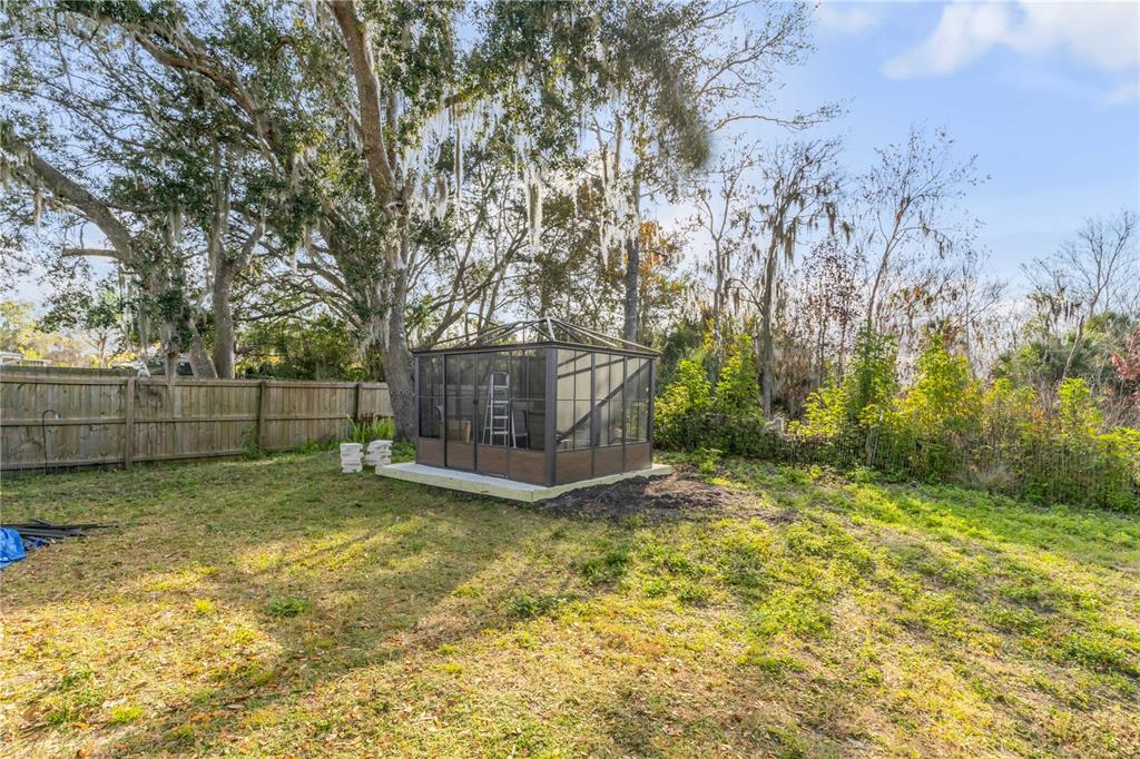 1017 36th Street Edgewater, FL 32141 - Photo 23 of 29 a view of a backyard with large tree and wooden fence