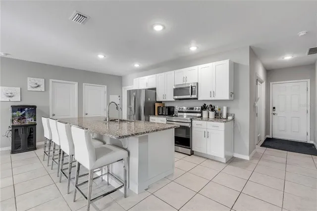 a kitchen with white cabinets and stainless steel appliances