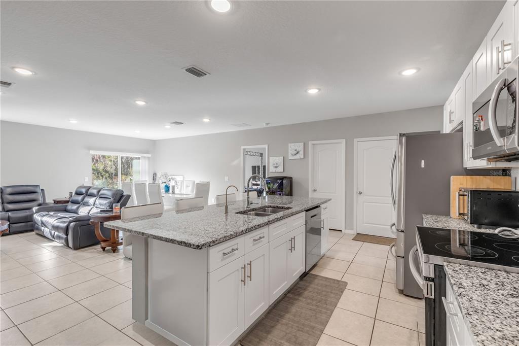 1017 36th Street Edgewater, FL 32141 - Photo 5 of 29 a kitchen with stainless steel appliances granite countertop a sink stove and cabinets