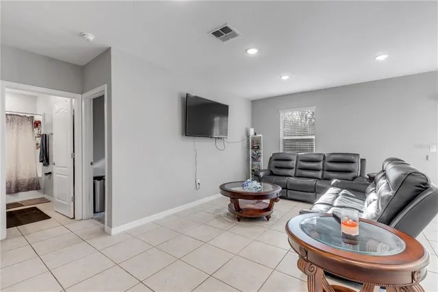 a living room with furniture a flat screen tv and kitchen view