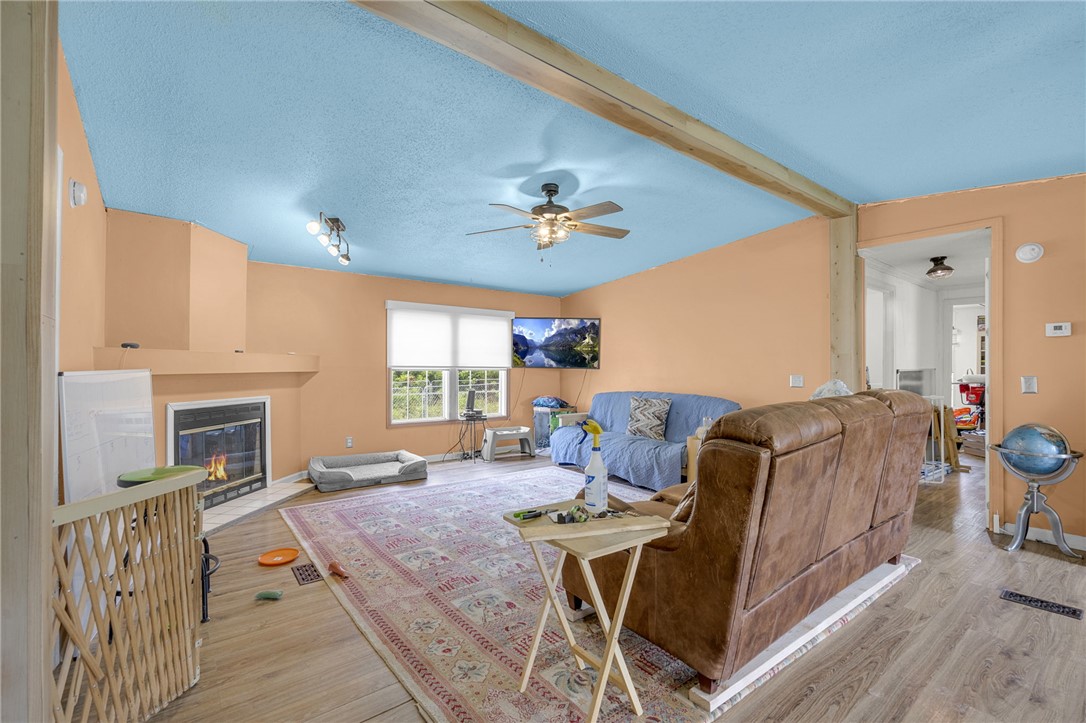 1549 Bethany Church Road Belton, SC 29627 - Photo 32 of 36 A corner fireplace and natural wood beams define this inviting living room.