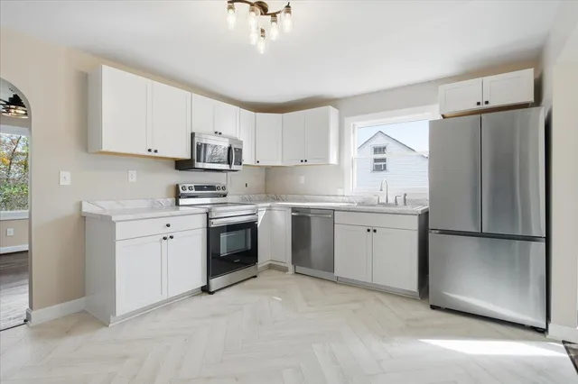 a kitchen with white cabinets and white stainless steel appliances