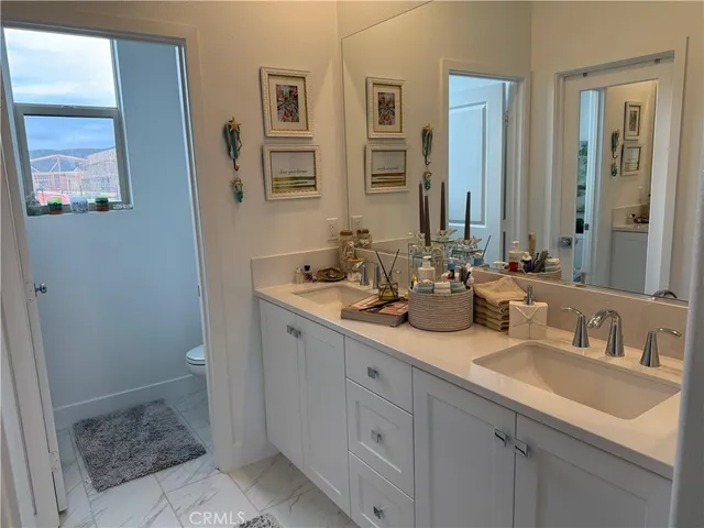 a bathroom with double sink and a mirror
