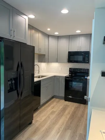 a kitchen with stainless steel appliances kitchen island granite countertop a refrigerator and a stove top oven