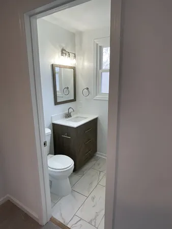 a bathroom with a toilet sink and mirror