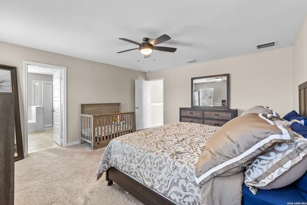 a bedroom with a bed a chandelier and dresser