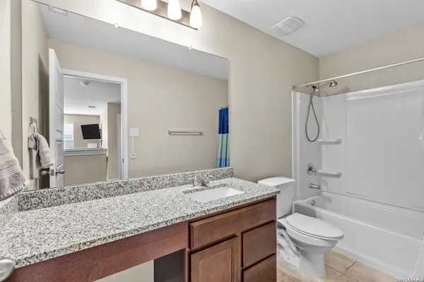 a bathroom with a granite countertop sink toilet and shower
