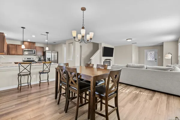 a dining room filled chandelier and wooden floor