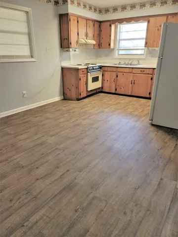 a large kitchen with stainless steel appliances granite countertop a stove a sink and a refrigerator