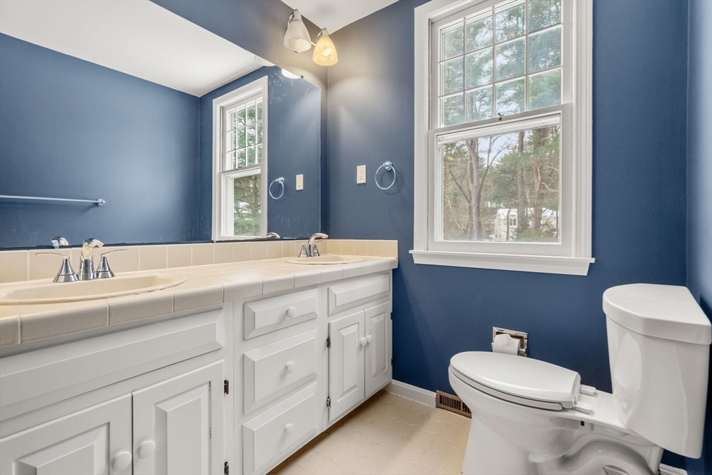 173 Conant Road Weston, MA 02493 - Photo 18 of 25 a bathroom with a double vanity sink toilet and a window