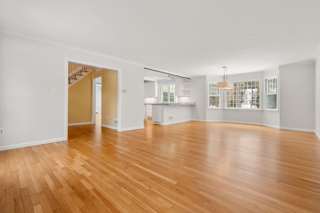 173 Conant Road Weston, MA 02493 - Photo 8 of 25 a view of empty room with wooden floor and kitchen view