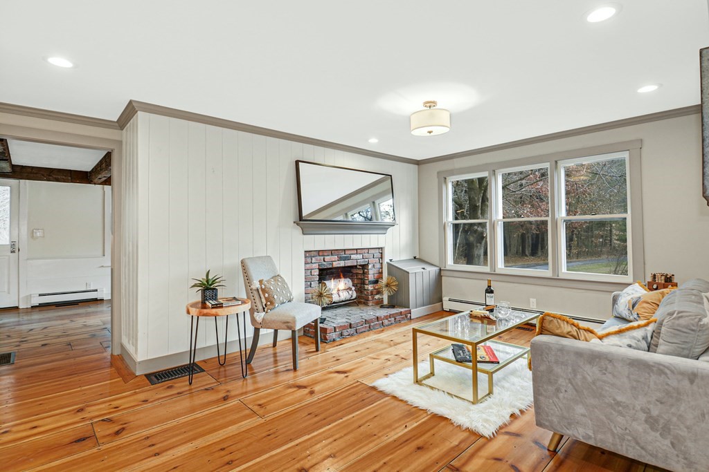 30 Nourse Road Bolton, MA 01740 - Photo 15 of 40 a living room with furniture a fireplace and a floor to ceiling window