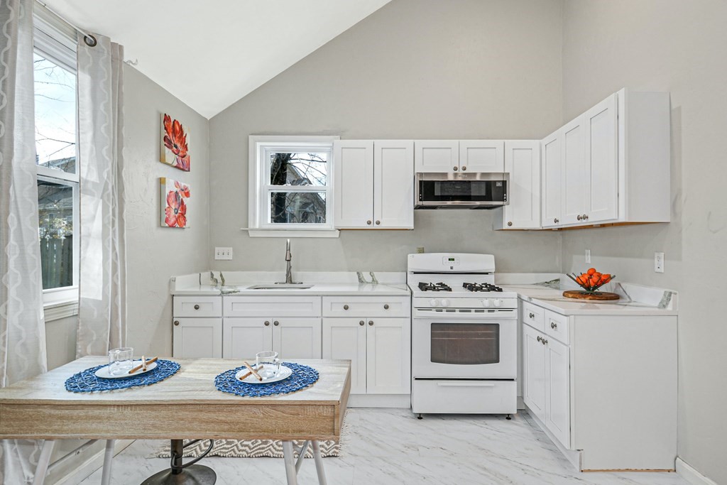 30 Nourse Road Bolton, MA 01740 - Photo 34 of 40 a kitchen with stainless steel appliances kitchen island granite countertop a sink a stove a table and chairs