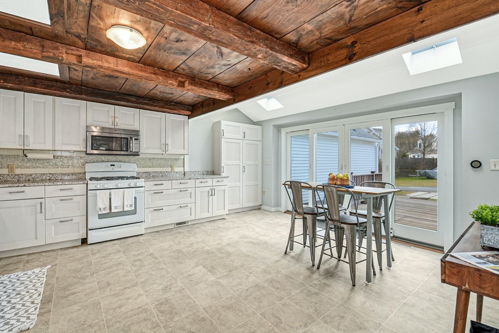 30 Nourse Road Bolton, MA 01740 - Photo 10 of 40 a kitchen with white cabinets and chairs