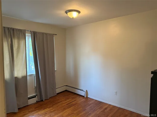 a view of a livingroom with an empty space and wooden floor