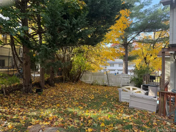 a backyard of a house with table and chairs under an umbrella