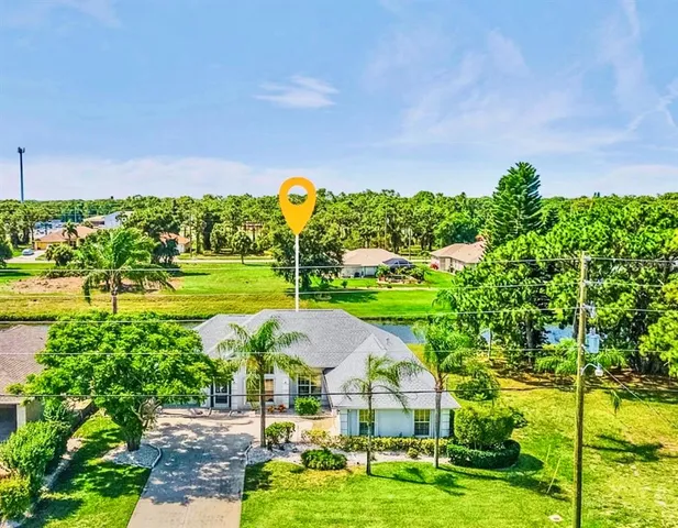 a view of a big yard with swimming pool and green space