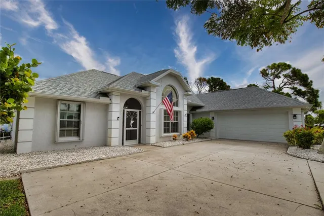 a view of a house with large windows and a small yard