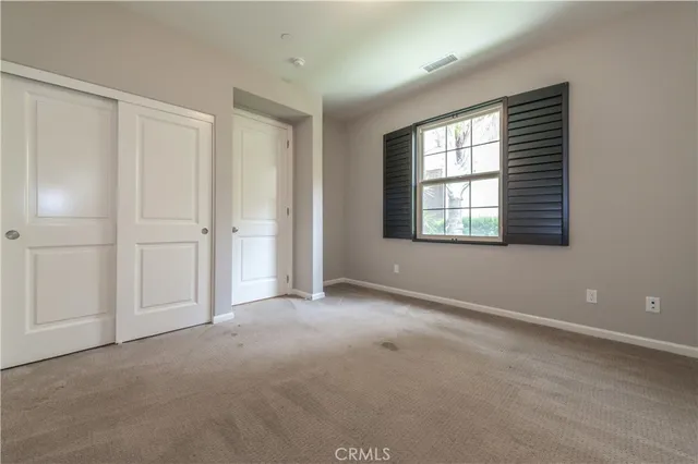 an empty room with windows and closet