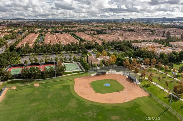 an aerial view of residential houses with outdoor space and trees