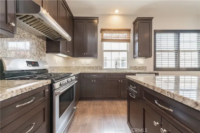 a kitchen with kitchen island granite countertop a sink cabinets and stainless steel appliances