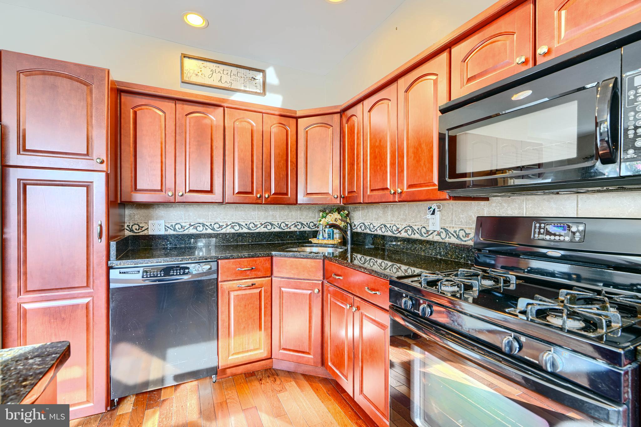 2 Haley Road Essex, MD 21221 - Photo 9 of 32 a kitchen with stainless steel appliances granite countertop a stove top oven a sink dishwasher and microwave with wooden floor