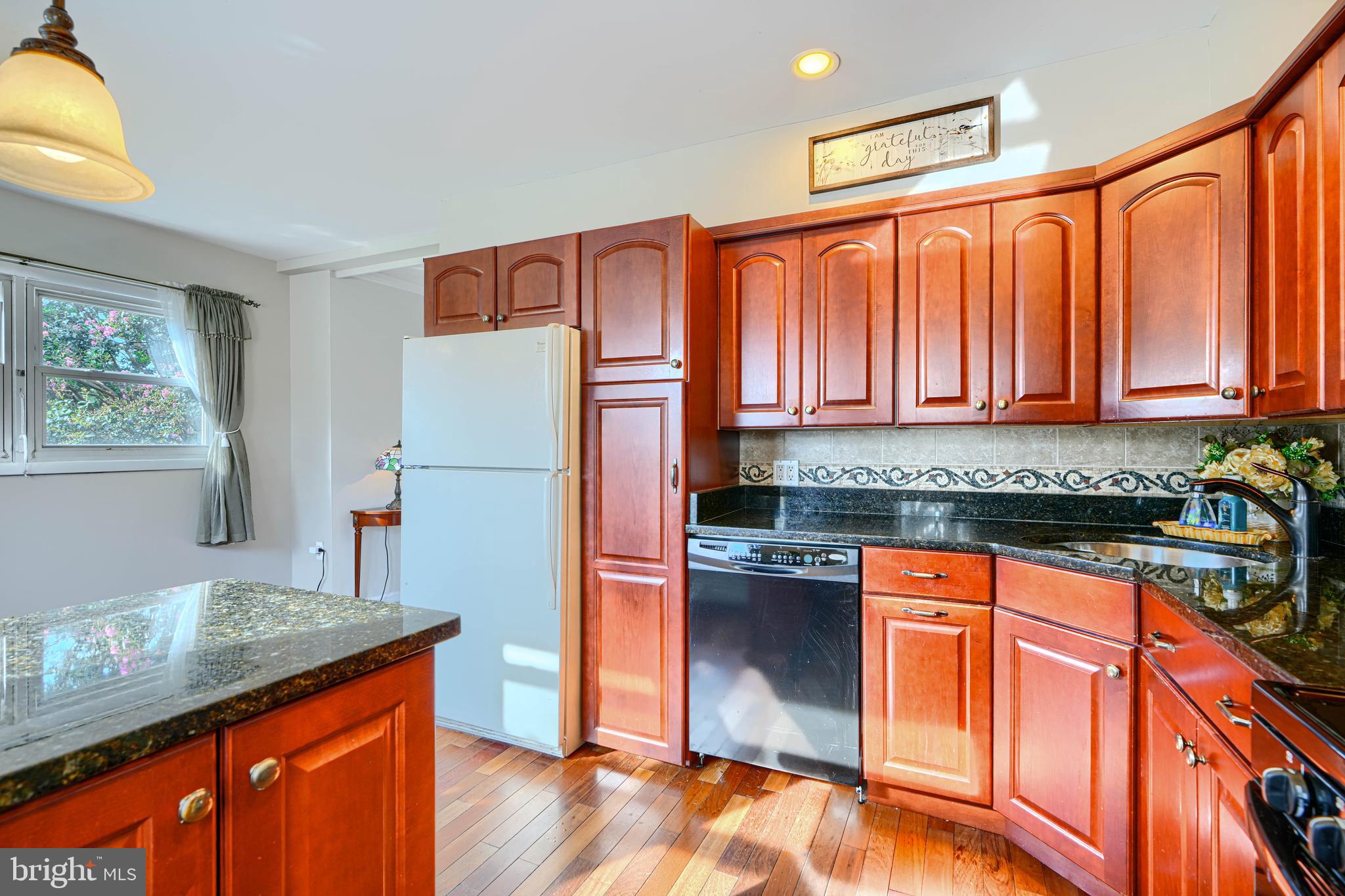 2 Haley Road Essex, MD 21221 - Photo 10 of 32 a kitchen with stainless steel appliances granite countertop a refrigerator a sink dishwasher a stove with wooden cabinets and floor