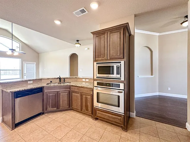 a kitchen with stainless steel appliances granite countertop a stove and a sink