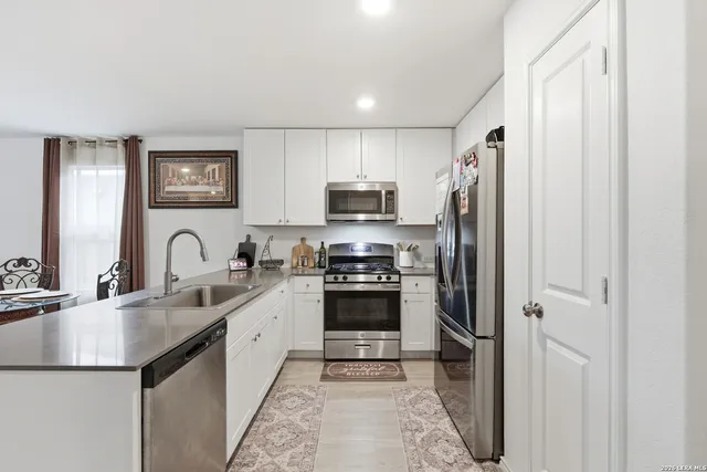 a kitchen with stainless steel appliances granite countertop a refrigerator and a sink