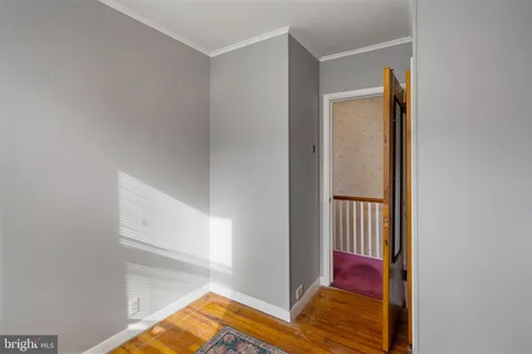 a view of a bedroom with wooden floor and closet