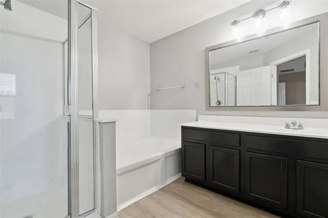 a bathroom with a tub a sink and mirror