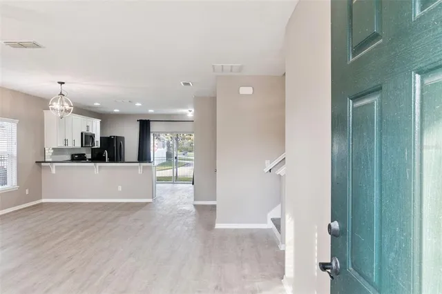 a view of a big room with wooden floor and windows