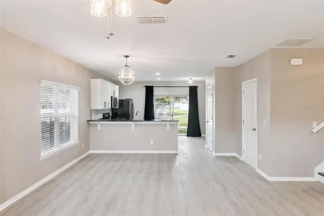 a view of a big room with wooden floor and windows