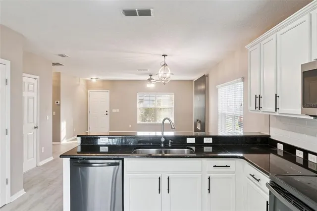 a kitchen with granite countertop a sink and cabinets