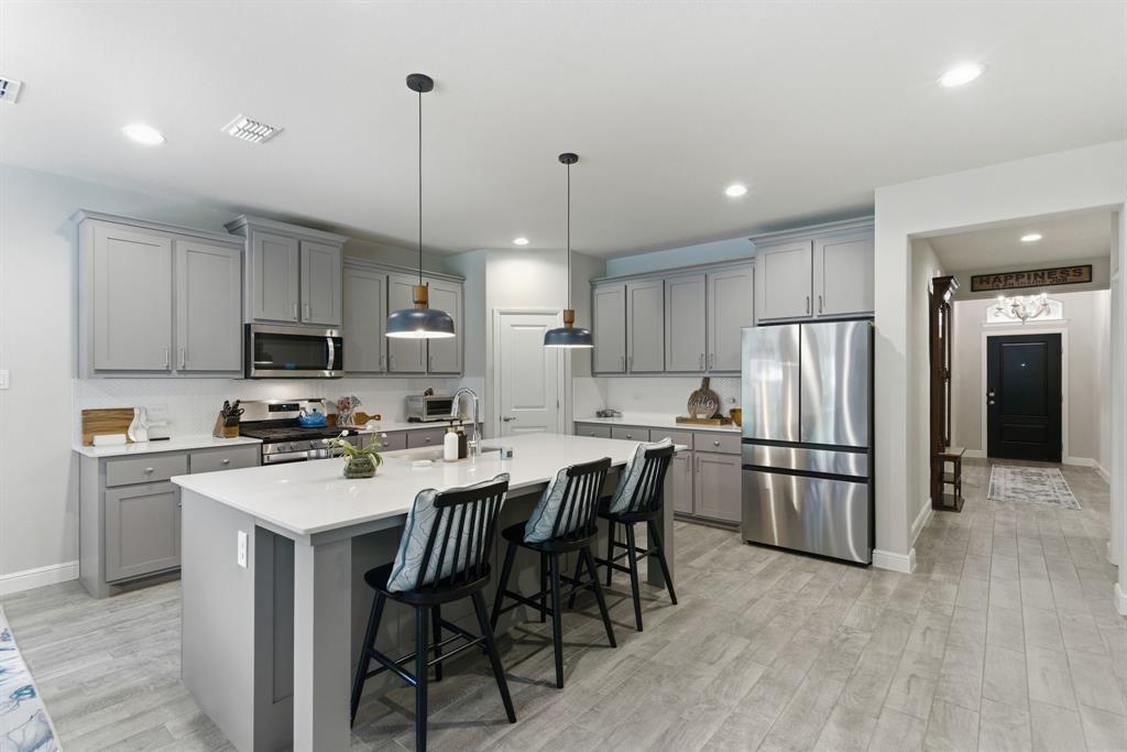 5621 Round Hl Road Denton, TX 76210 - Photo 6 of 27 a kitchen with stainless steel appliances granite countertop a stove a refrigerator a kitchen island a sink and a refrigerator