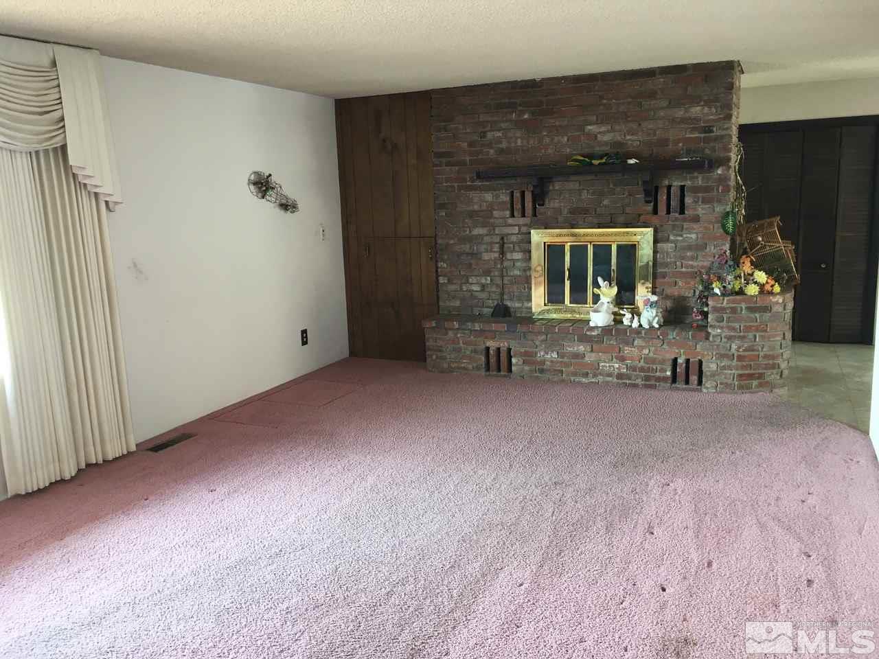 4305 Drake Way Washoe Valley, NV 89704 - Photo 5 of 21 an empty room with fireplace and mirror