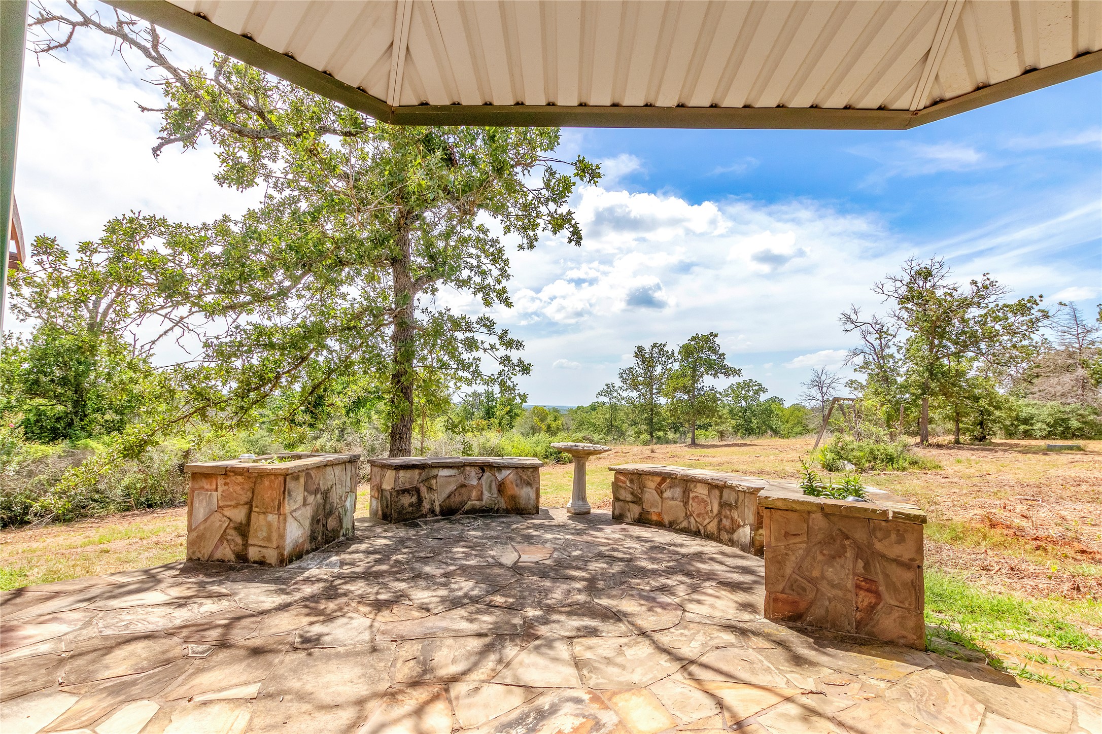 1004 22 Hills Road Gause, TX 77857 - Photo 36 of 37 An inviting stone patio offers a secluded outdoor retreat with scenic views.