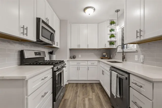 a kitchen with stainless steel appliances granite countertop a sink and stove top oven