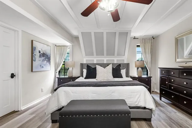 a large bed sitting in a bedroom next to a window and a chandelier