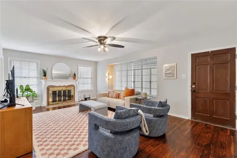 a living room with furniture fireplace and wooden floor